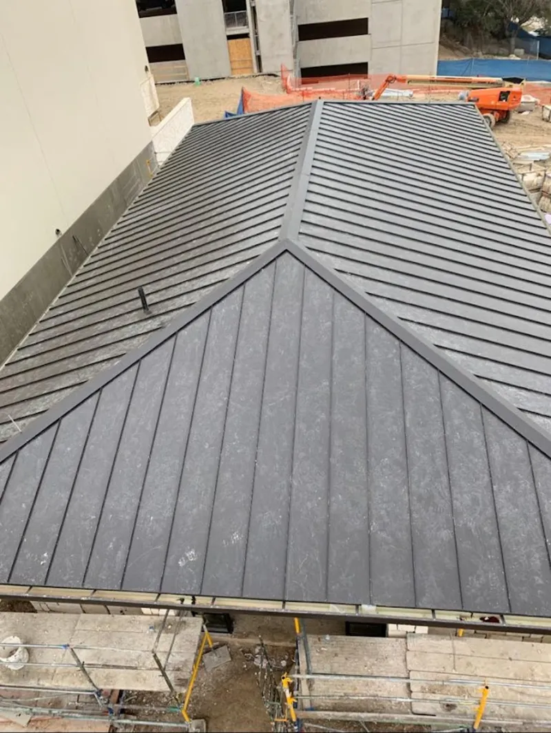 Commercial metal roof construction with crane equipment in Garden City